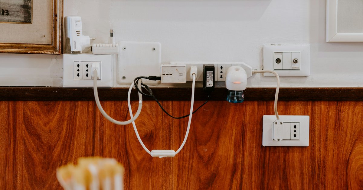 壁のコンセントと電源タップから垂れるコード