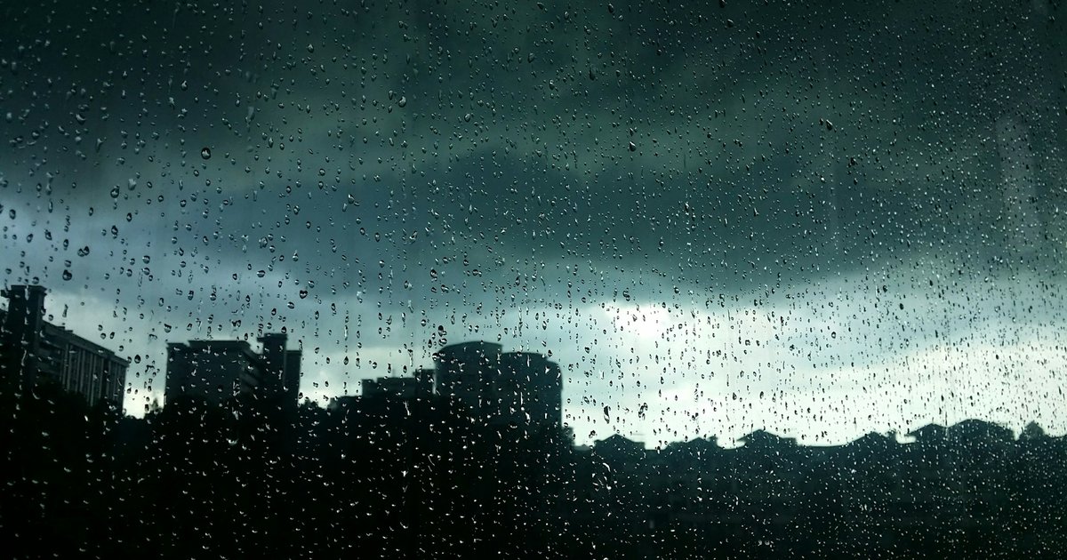 雨粒のついた窓と曇り空